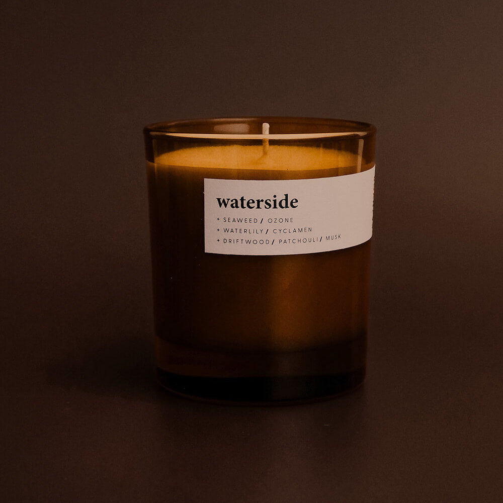 Candle with a label titled 'waterside' on a dark background